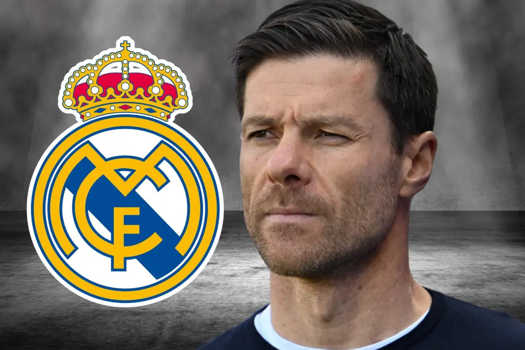 Xabi Alonso junto al escudo del Real Madrid.
