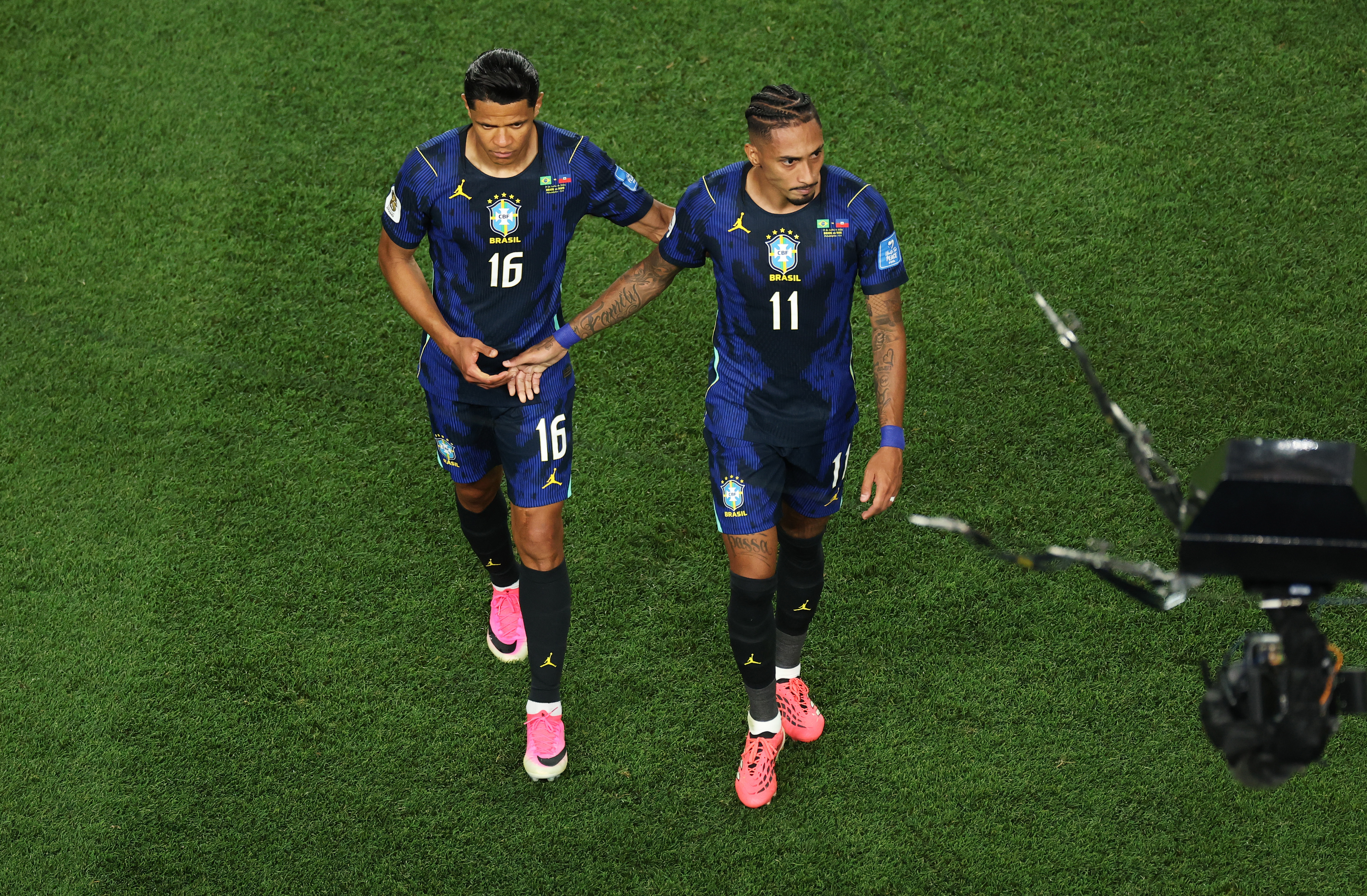 Raphinha, retirándose consolado por un compañero de Brasil | Foto: Kevin C. Cox/Getty Images